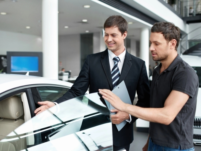 Car Salesman at A Dealership showing somone a car